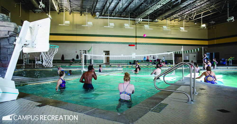Students play volleyball in the pool.