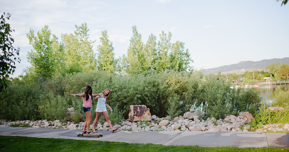 Students skateboarding down sidewalk