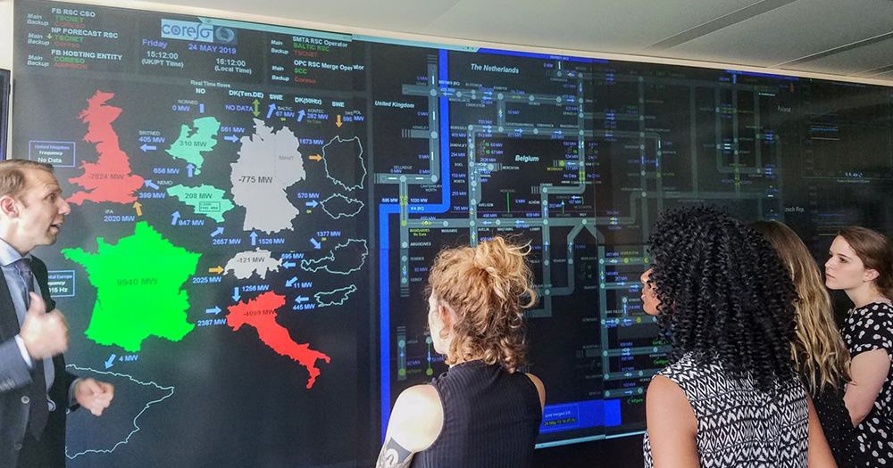 students look at a complex world map on a wall