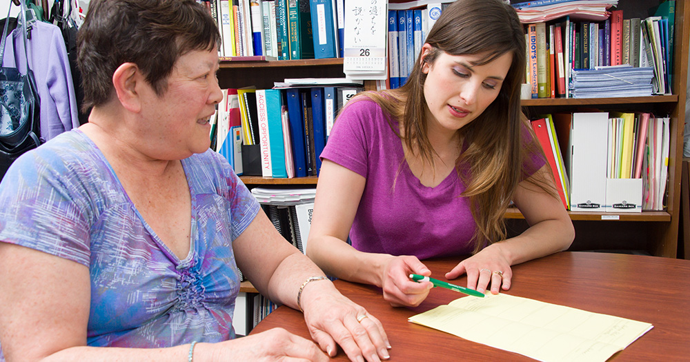 Social work student meeting with a community member in office