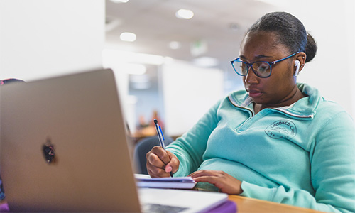 Student with notebook and laptop