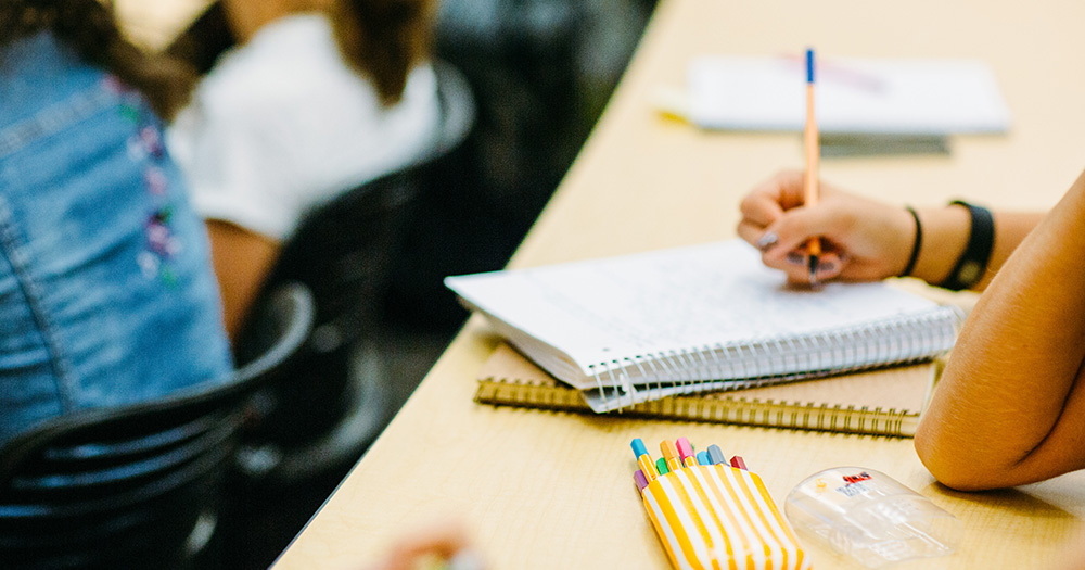 a colorado state student colors and designs in her notes in a class