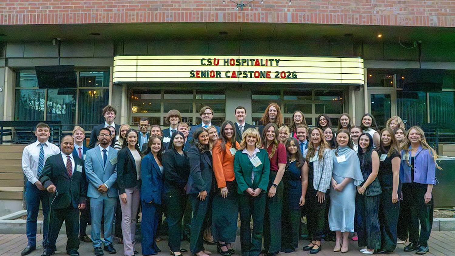 Seniors in Hospitality Management pose in front of their capstone event