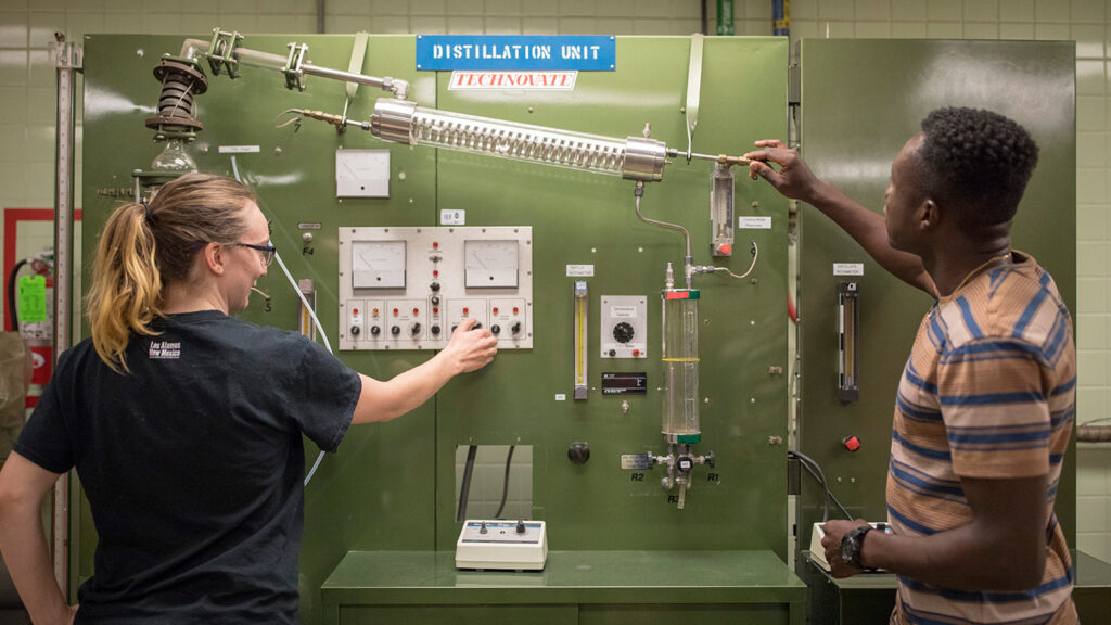 Chemical and Biological Engineering students work with a distillation unit in a lab