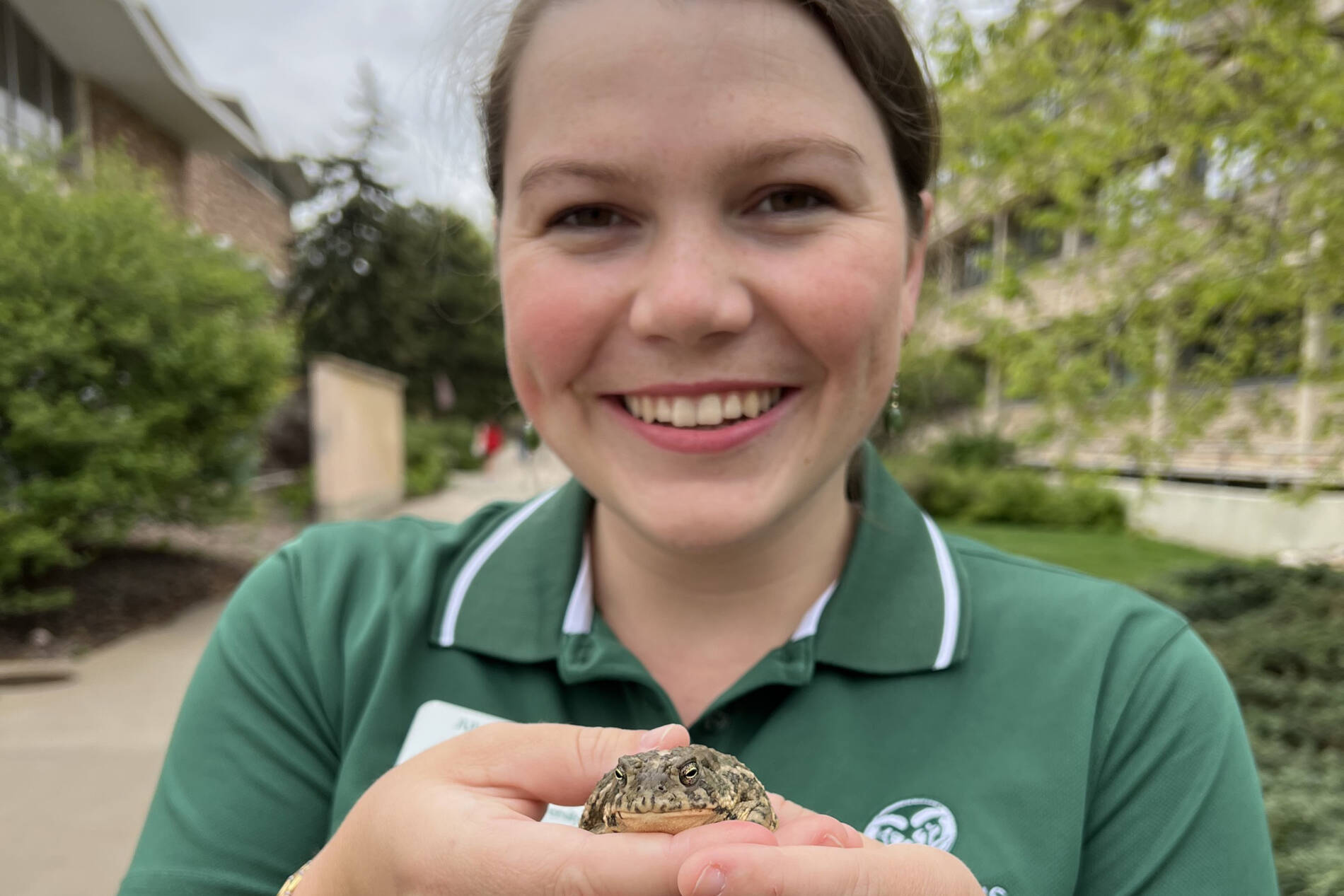 Juliette holding a woodhouse's toad in front of Eddy Hall