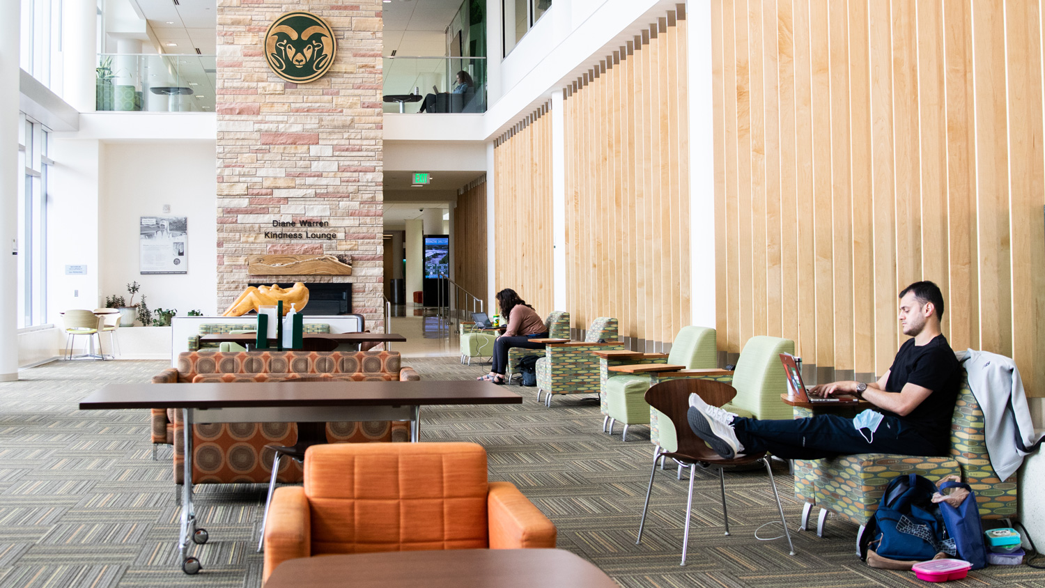 Student kicks back in chair in a brightly lit, open space lounge