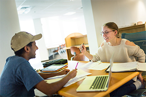 Students have a lively interaction over a study table