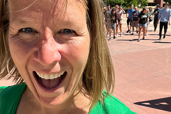 Heather taking a selfie on campus and smiling big