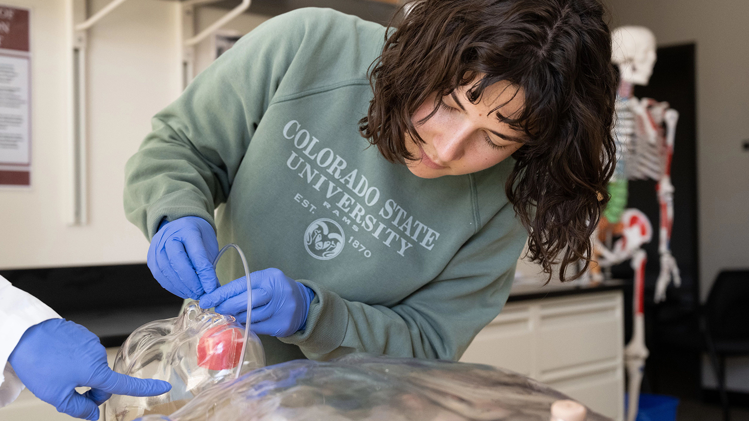 A student learns how to insert a feeding tube.