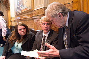 Students work with a government official at the state capitol