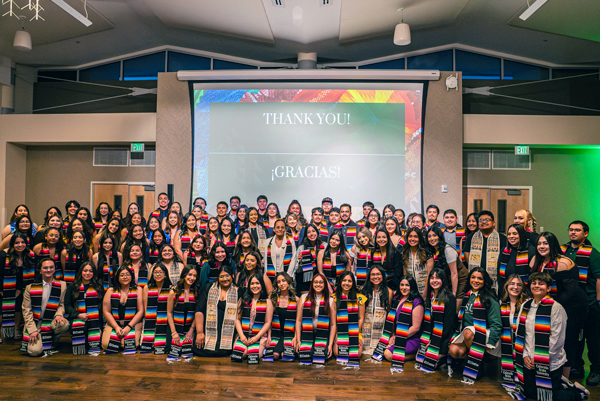 A large group of college students celebrate graduation with El Centro