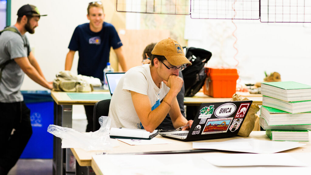 A student focuses on a laptop screen in a lab