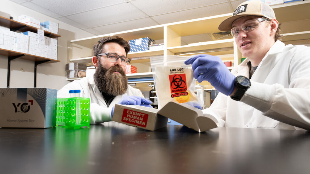 A student and professor in public health work with biohazard materials in a lab
