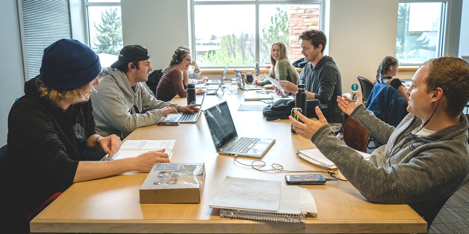 Group of students at long table studying