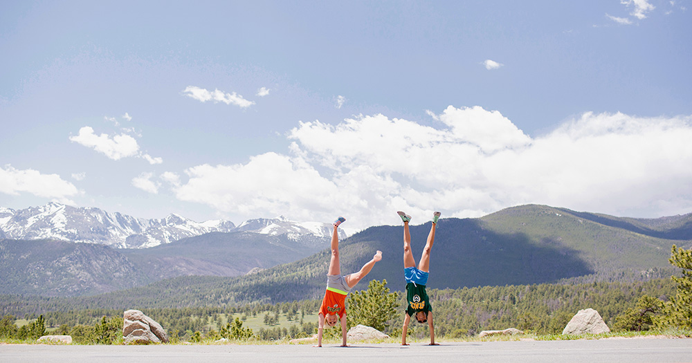 Students doing handstands with mountains in background