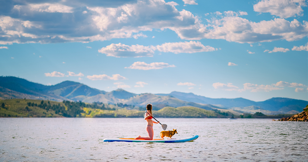 A student paddle boards on the Horsetooth Reservoir