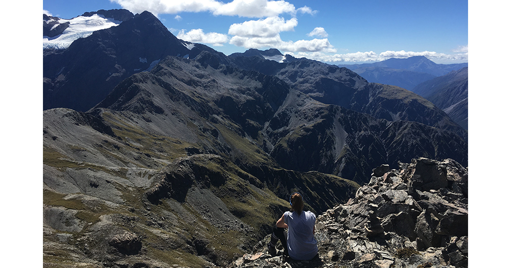 Rebecca hikes to a beautiful summit in New Zealand.