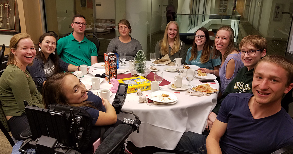 A group of CSU scholars sit around a dinner table at an event.