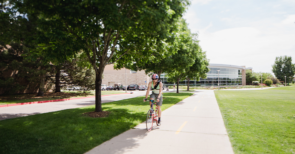 A student rides on the bike trails at CSU.
