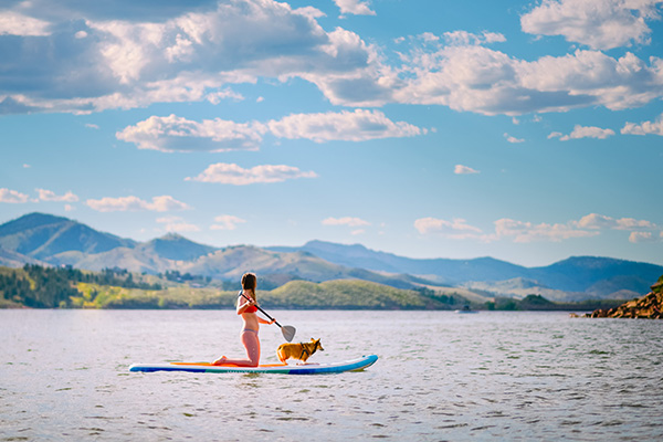 Woman and dog on paddleboard at Horsetooth Reservoir in Fort Collins