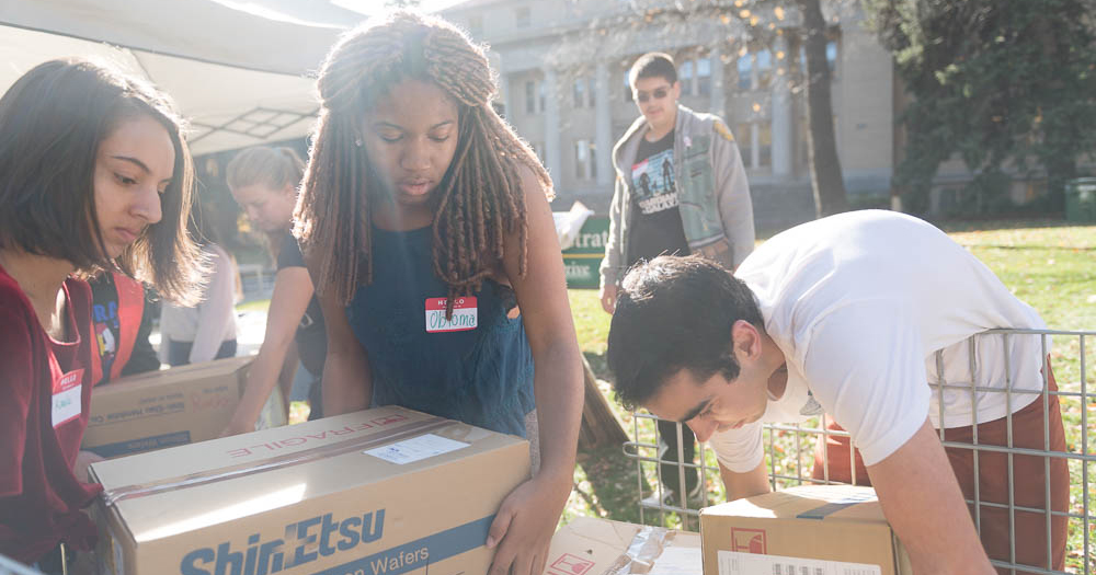 Students helping weigh boxes of food