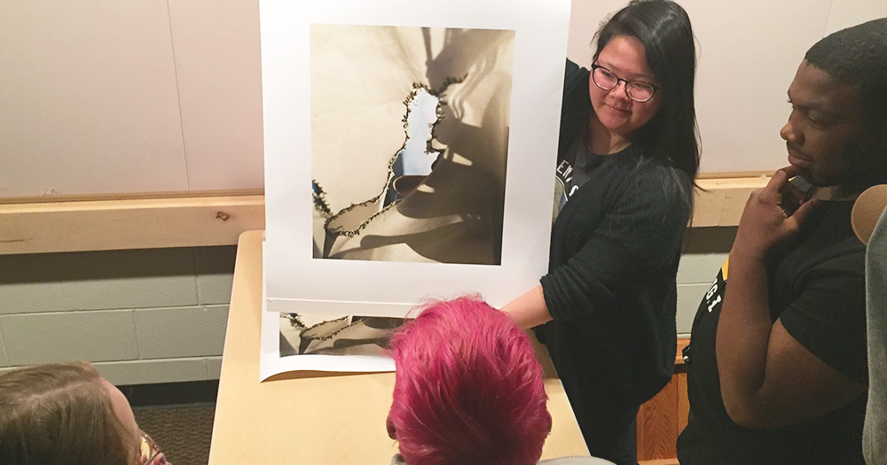 A photography student showcases her work to peers