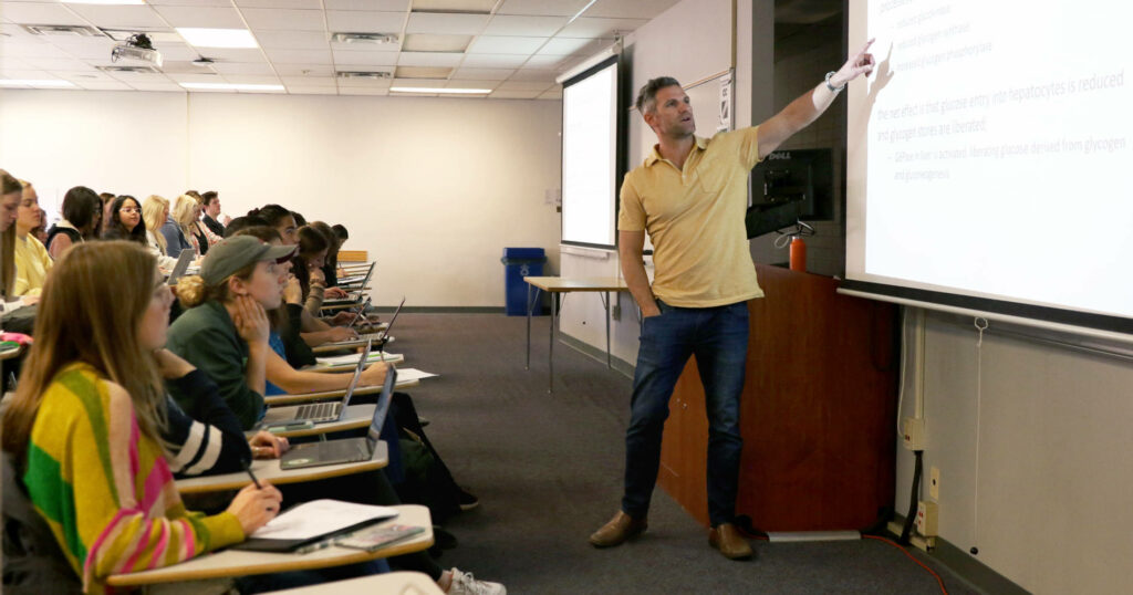 A nutrition professor guides students in a lecture class.
