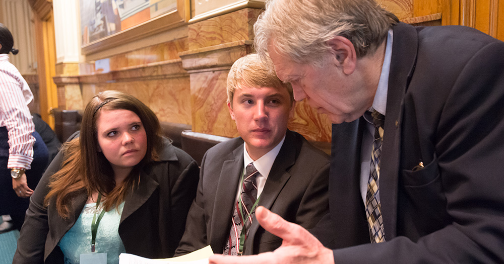students talk to a lawyer in a courtroom