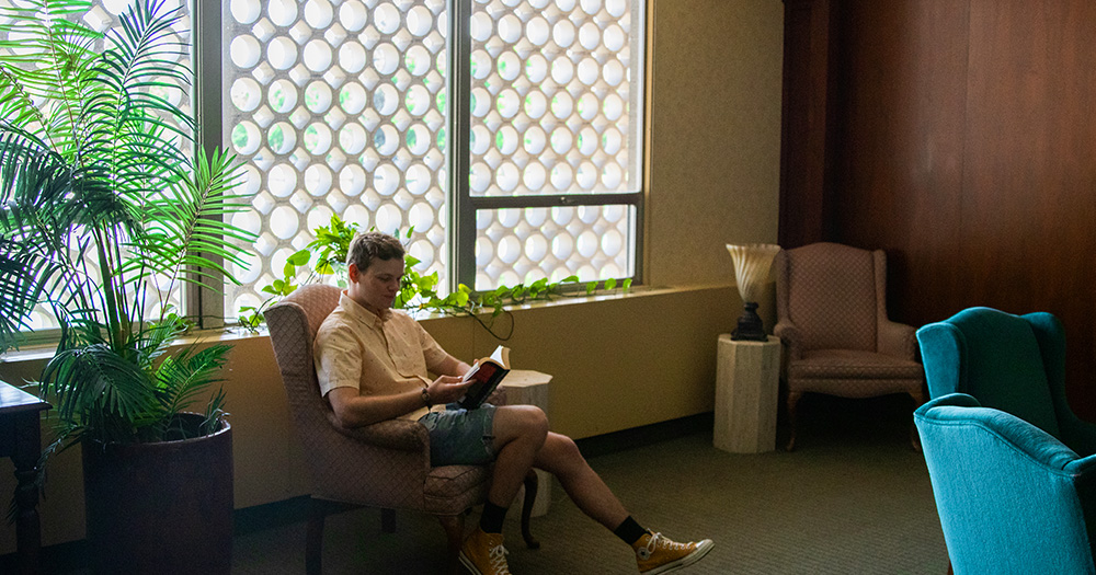 A student reads in a cozy armchair