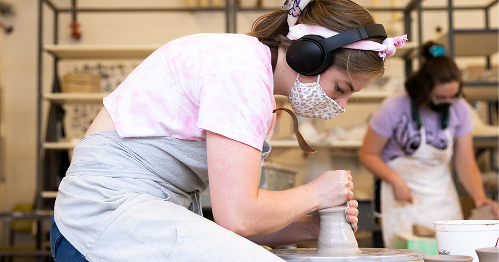 A colorado state pottery student works at a wheel