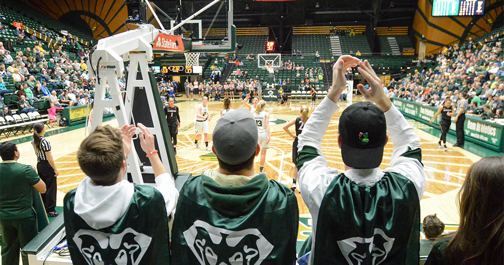 Students wearing Ram-adorned capes cheers on the Lady Rams at a basketball game in Moby Arena.