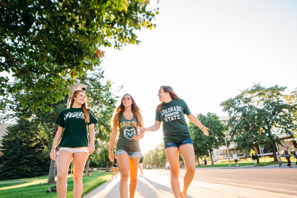 Three women wearing CSU shirts walk down the street