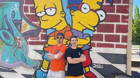 Fletcher and his brother standing by Simpsons art