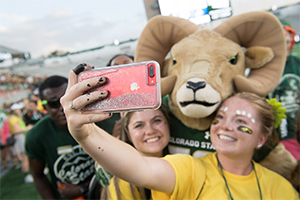 Students taking selfie with CAM mascot
