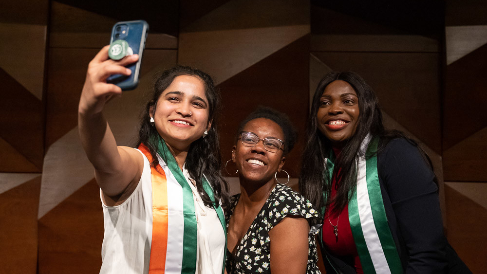 International students take a selfie at graduation