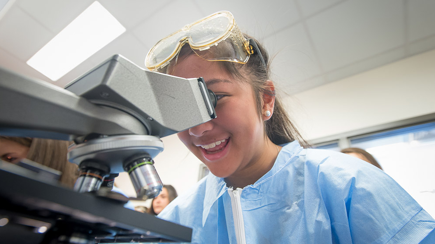 A student looks into a microscope