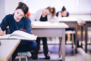 a student focuses on papers on a desk