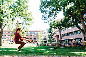 A student balances on a slack line near the CSU dorms