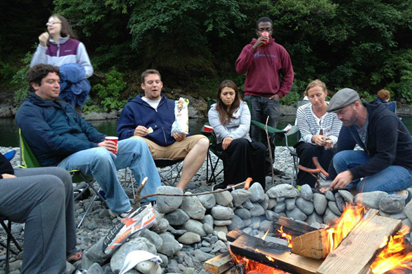 Jonathan hanging out with friends around a campfire