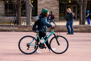 Student walking with bike through CSU Plaza.